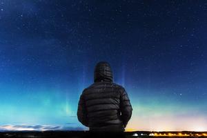 Picture of a person in a coat looking at the night sky