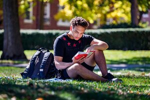 Student stuydying on grass. The University of Illinois quad and a beautiful day make for a perfect place to study outside.